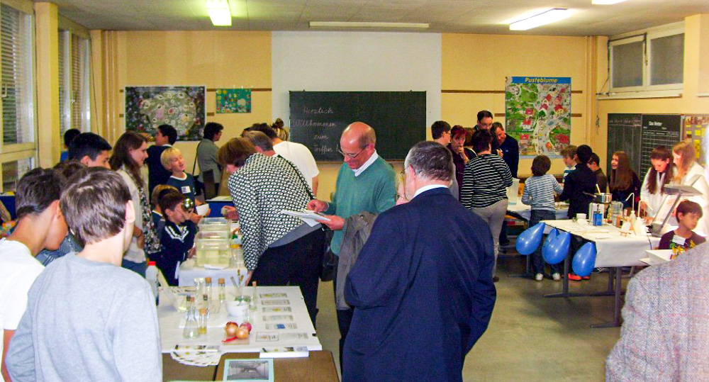 Foto: Erwachsene und Kinder auf einer Projekt-Ausstellung